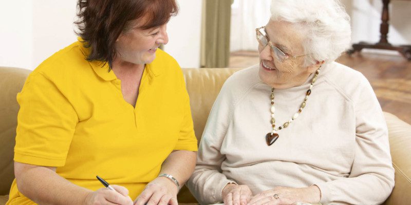 Mitarbeiterin im Gespräch mit einer Seniorin
