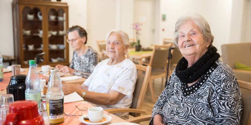Gruppe Seniorinnen an gedecktem Tisch