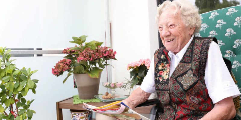 Lachende Seniorin auf dem Balkon